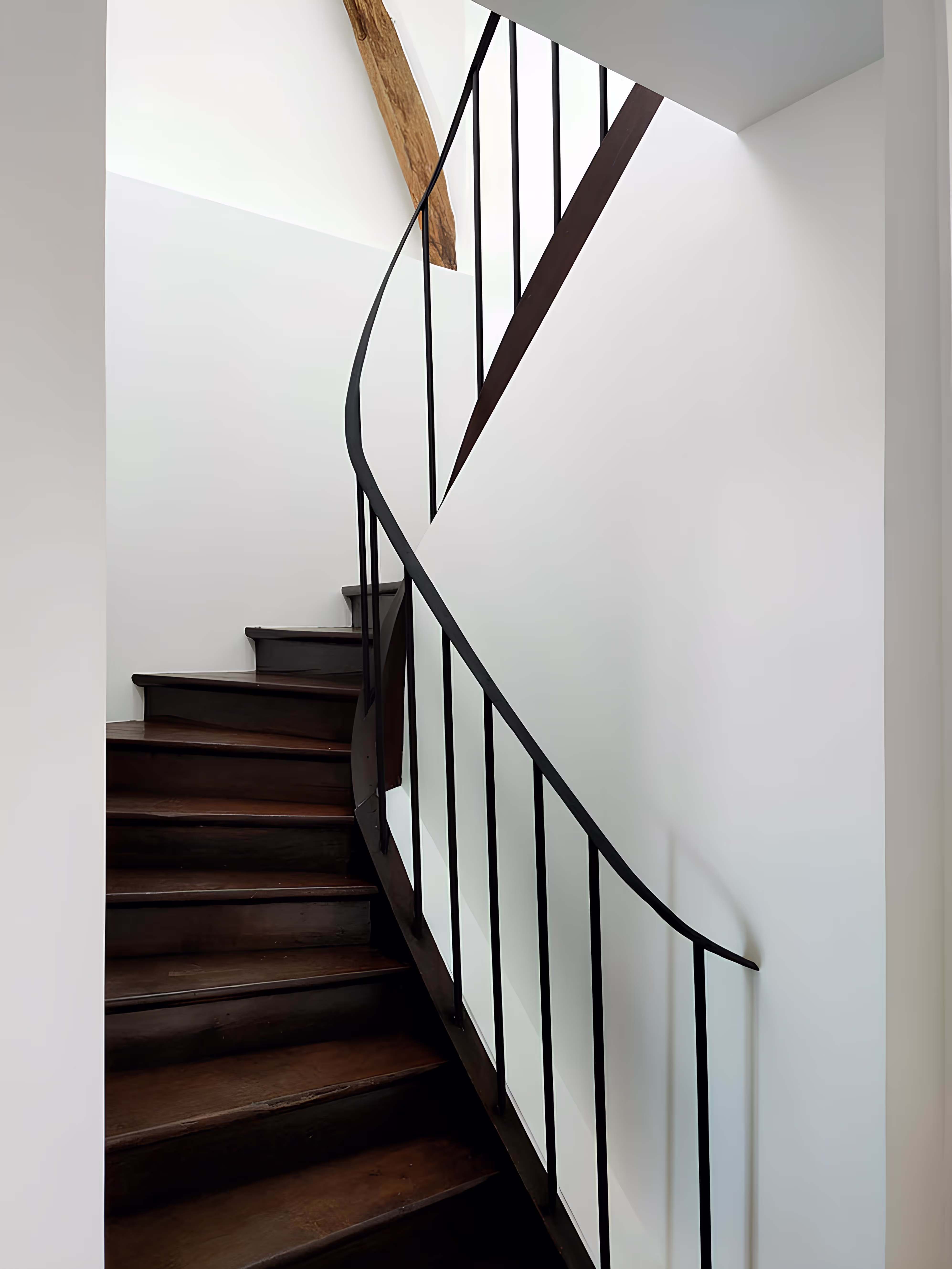 Escalier rénové en bois foncé avec garde-corps métallique, Appartement Villeneuve à Villeneuve-sur-Auvers, réalisé par SINA Architecture.